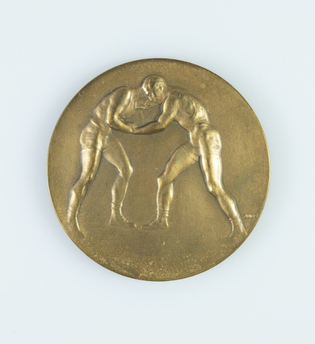 Goldmedaille mit zwei ringenden Männern auf weißem Hintergrund