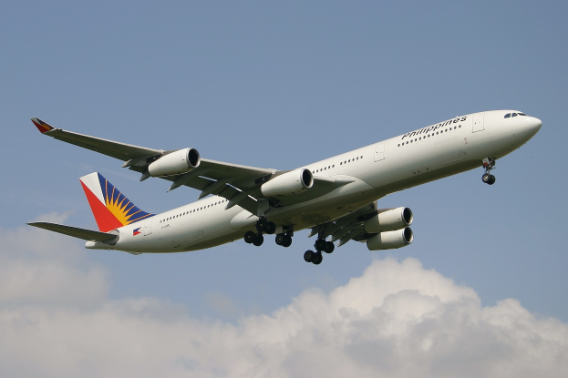 Philippine Airlines Airbus A330-300 im Flug mit ausgefahrenem Höhenruder vor einem Hintergrund aus weißen Wolken.