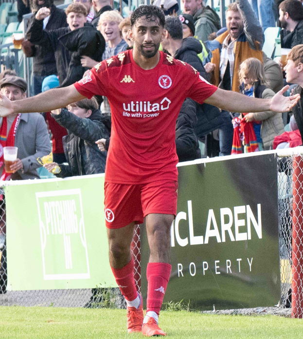 Ein Fußballspieler in roter Uniform rennt mit ausgestreckten Armen auf einem Feld während eines Matches zwischen Middlesbrough FC und Swansea City in der Sky Bet Championship, mit Zuschauern und einem Banner im Hintergrund.