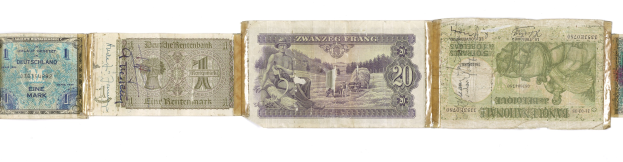 Ein altes Buch mit verschiedenen Nennbeträgen alter deutscher Banknoten darauf gestapelt.