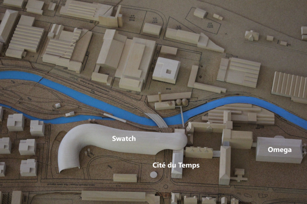 Ein Miniaturmodell einer Stadt mit einem Fluss, Gebäuden, Straßen und Text.