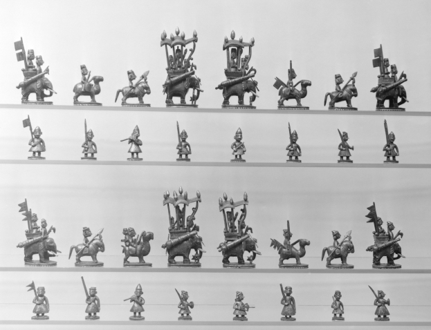 Black and white photo of a display case with shelves holding an assortment of neatly arranged miniature toys.