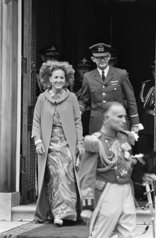 Schwarzes und weißes Foto von Queen Elizabeth II und Prinz Philip, Duke of Edinburgh, bei der Ankunft in Buckingham Palace in formeller Kleidung, mit einer Menge und dem Palastportal im Hintergrund.
