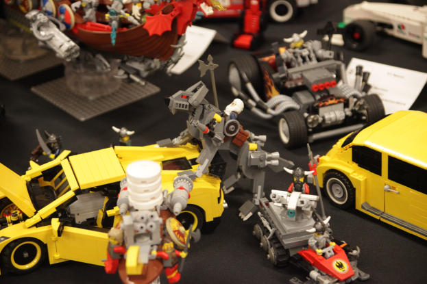 Ein Tisch, der mit verschiedenen Lego-Stücken übersät ist, darunter ein Spielzeugauto und ein Rad.