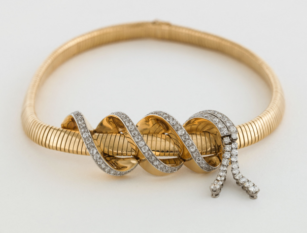 Ein verdrehter 18k Gelbgold-Armreif mit funkelnden Diamanten.