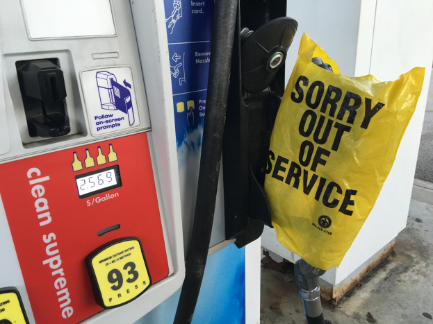 Tankstelle mit einem "Entschuldigung, außer Betrieb" Schild und einer gelben Abdeckung, die als Kraftstoffspender gekennzeichnet ist.