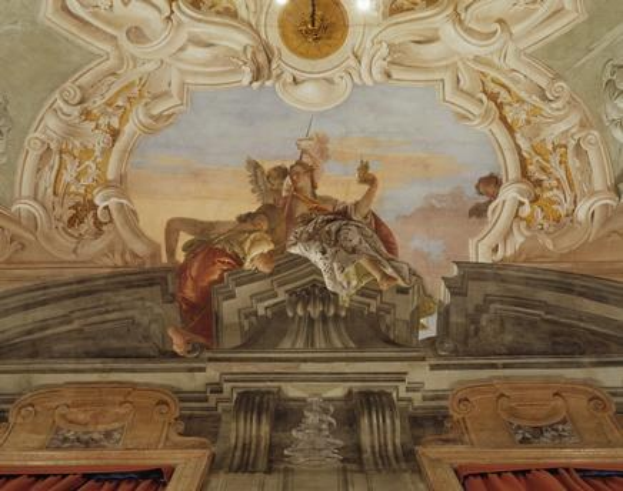 Deckengemälde mit einer Uhr, Skulpturen und roten Vorhängen darunter, das eine lebendige Opernszene mit detaillierten Elementen darstellt.