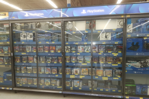 A PlayStation Store aisle with various video games displayed on shelves under ceiling lights.