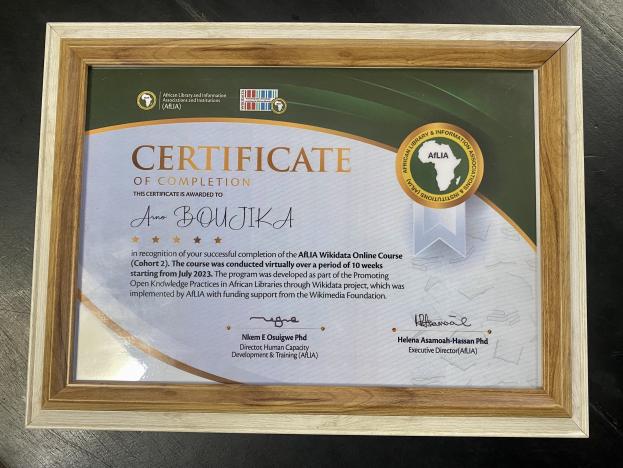 Ein gerahmtes Abschlusszertifikat mit Text, das auf einem Tisch steht.