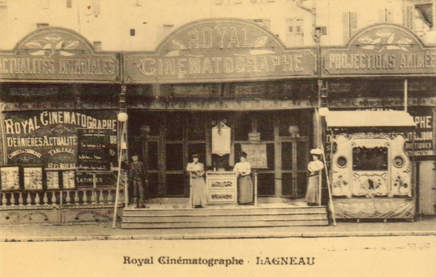 Old black and white photograph of the Royal Cinematographe in Ligneau, France, with a few people standing in front of the building, which has boards and lights adorning it, and text at the bottom.