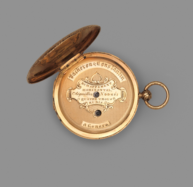 Goldene Taschenuhr mit geschlossenem Deckel auf grauem Hintergrund, mit eingravierter Inschrift, die wahrscheinlich die Marke oder Art angibt.