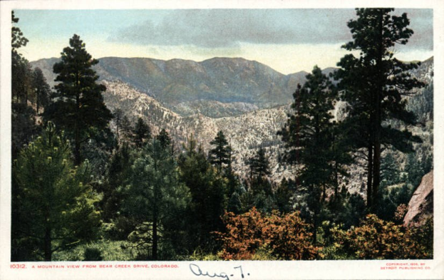 Blick auf den Mount Glennon von der Bear Creek Drive in Colorado mit Bäumen, Hügeln und bewölktem Himmel, mit Text am unteren Rand.