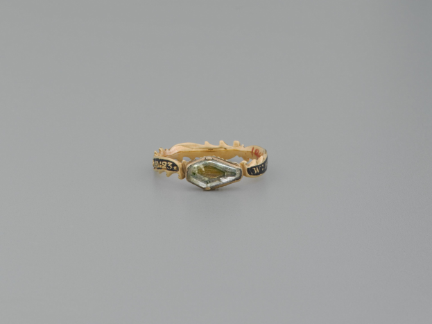 Ein goldener Ring mit einem Marquise-Schliff-Diamant in der Mitte, umgeben von einem Halo aus kleineren Diamanten, in einem goldenen Ring.