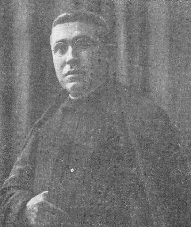 Schwarzes und weißes Foto eines Mannes in Priesterroben, der eine Brille trägt und vor einem Vorhang mit Text am unteren Rand steht, der "Erzbischof von Canterbury" lautet.