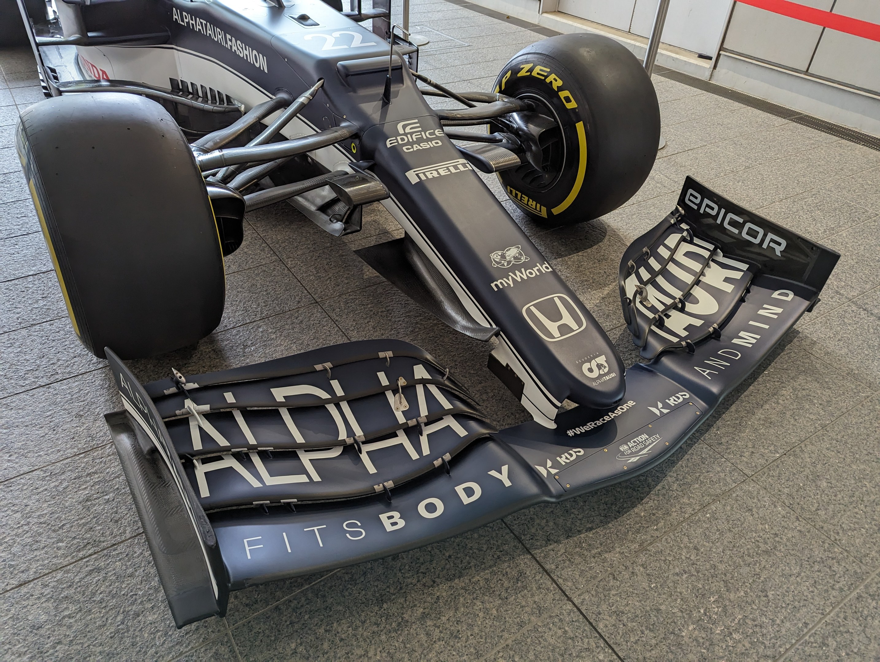 Ein schwarzer und weißer McLaren MP4-31 Formel-1-Rennwagen im McLaren-Museum mit einem großen Heckflügel und aerodynamischem Design.