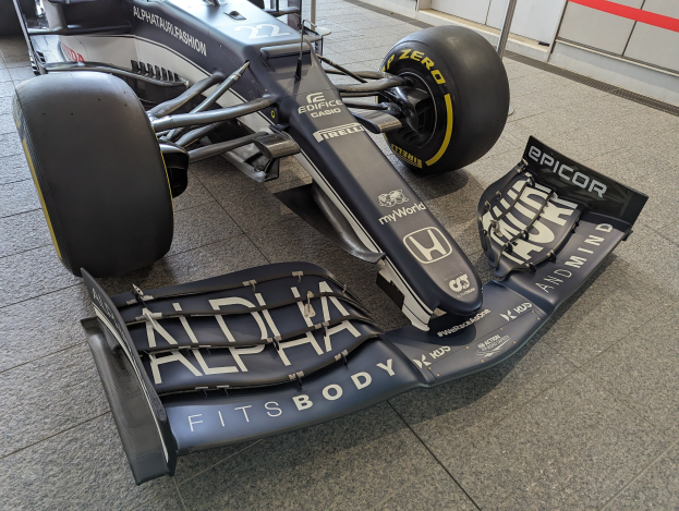Ein schwarzer und weißer McLaren MP4-31 Formel-1-Rennwagen im McLaren-Museum mit einem großen Heckflügel und aerodynamischem Design.