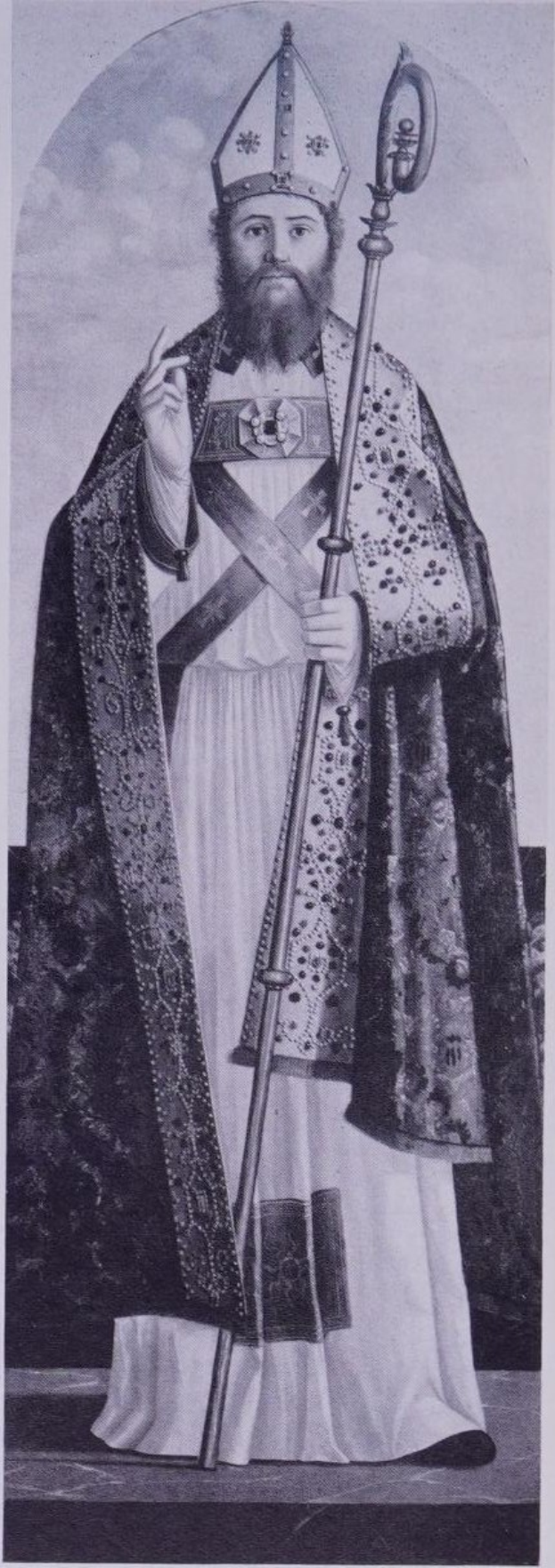 Schwarzes und weißes Foto eines Mannes in Priesterkleidung, der eine Mütze trägt und einen Stab hält, identifiziert als Erzbischof von Canterbury.