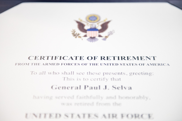 Rahmenurkunde für den Ruhestand der United States Air Force mit blauem Rand, mit einer schwarzen Textschrift und einem zentralen Schild-Logo mit einem Stern, einem Lorbeerkranz und einer 'Ruhestand'-Banderole.