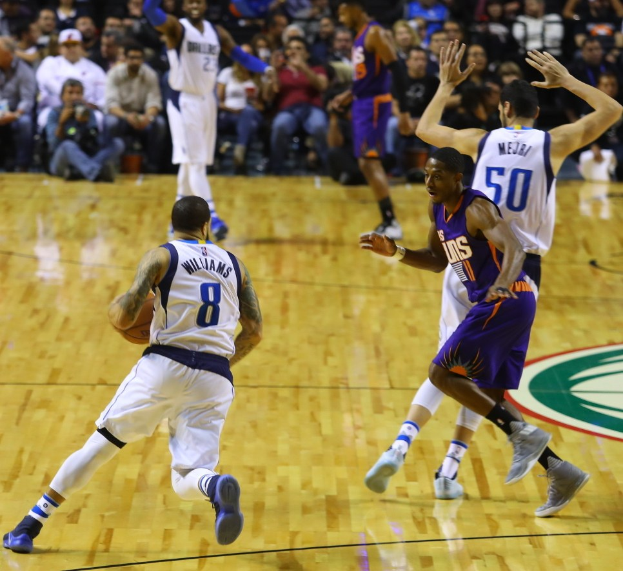 Basketballspiel zwischen Oklahoma City Thunder und Dallas Mavericks mit Spielern auf dem Feld und Zuschauern in den Rängen.