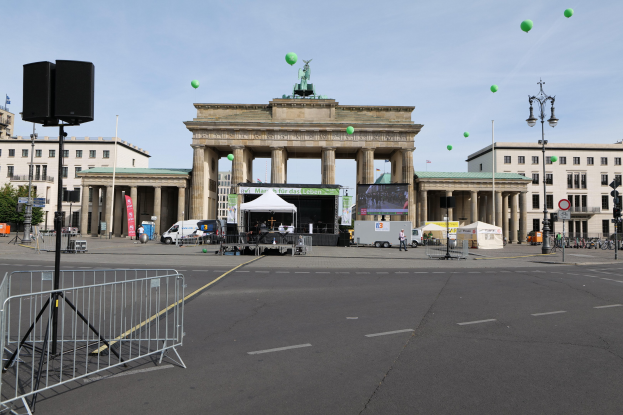 Brandenburger Tor in Berlin, Deutschland, mit seinen klassizistischen Säulen und Statuen, umgeben von urbanen Elementen und festlichen grünen Luftballons während des Berlin-Marathons.