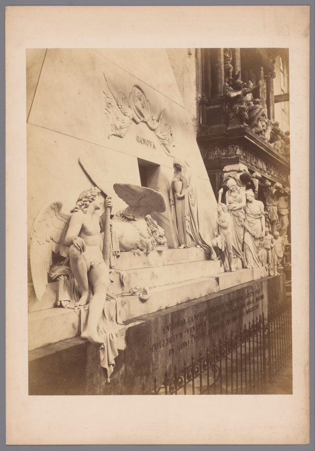 Altes Schwarz-Weiß-Foto einer detaillierten Statue an der Seite eines Gebäudes, mit einem Geländer davor und einer Wand dahinter.