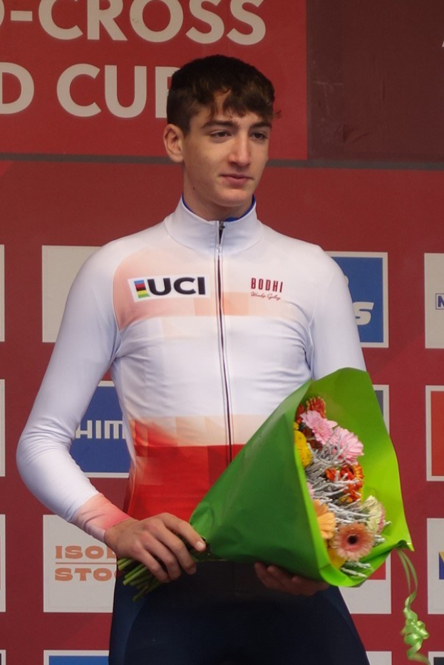 Mann auf einem Podium mit einem Strauß Blumen, der einen Sieg mit selbstbewusster und stolzer Haltung feiert.