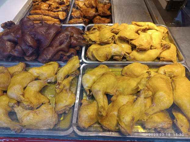 Vitrine mit Tabletts voller verschiedener Hühnerflügel auf einem Tisch, zeigt verschiedene Farben und Größen von goldbraun bis knusprig weiß.