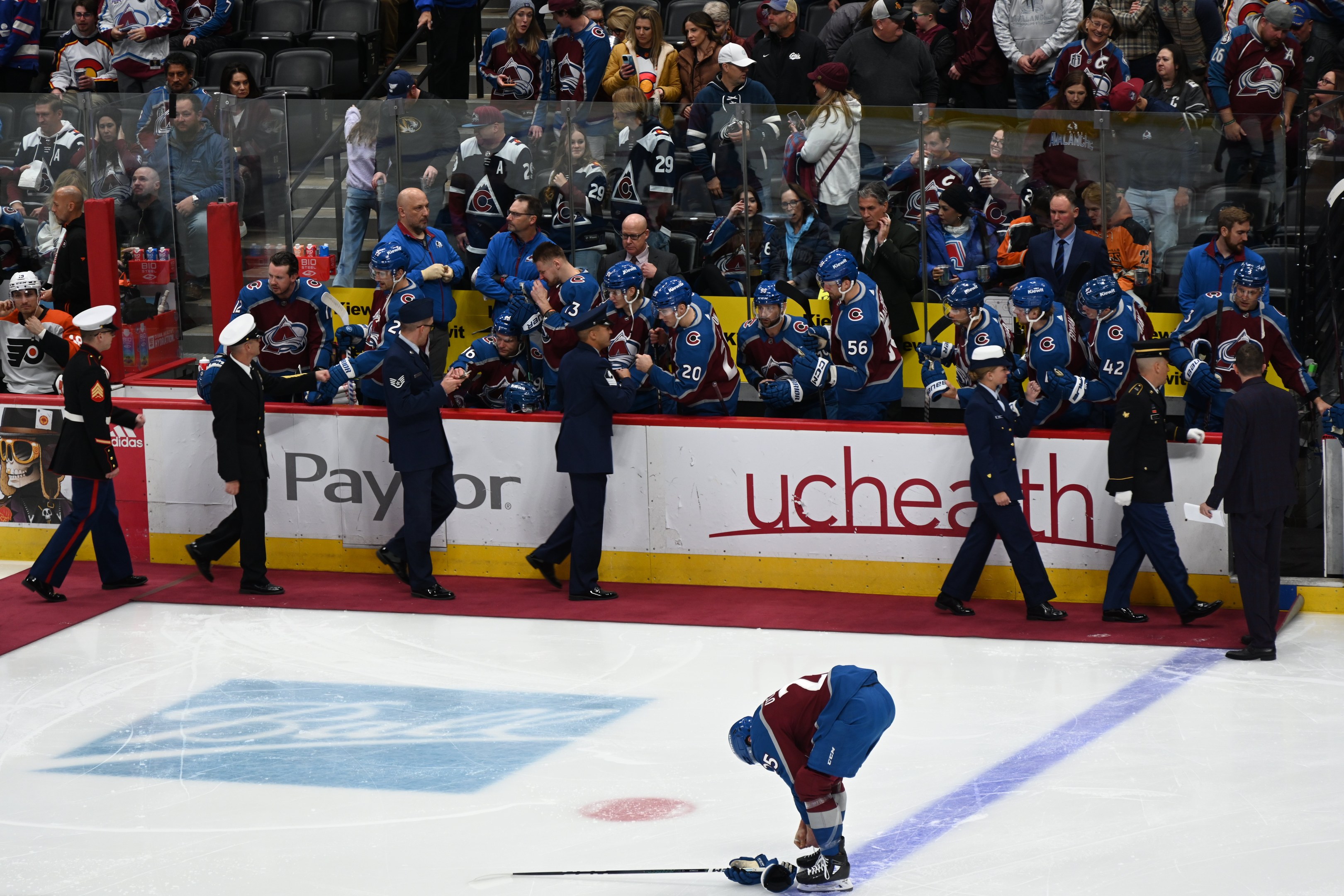 Hockeyspieler auf dem Eis umgeben von Fans und Teammitgliedern während eines Spiels zwischen Colorado Avalanche und San Jose Sharks am 24. März 2015.