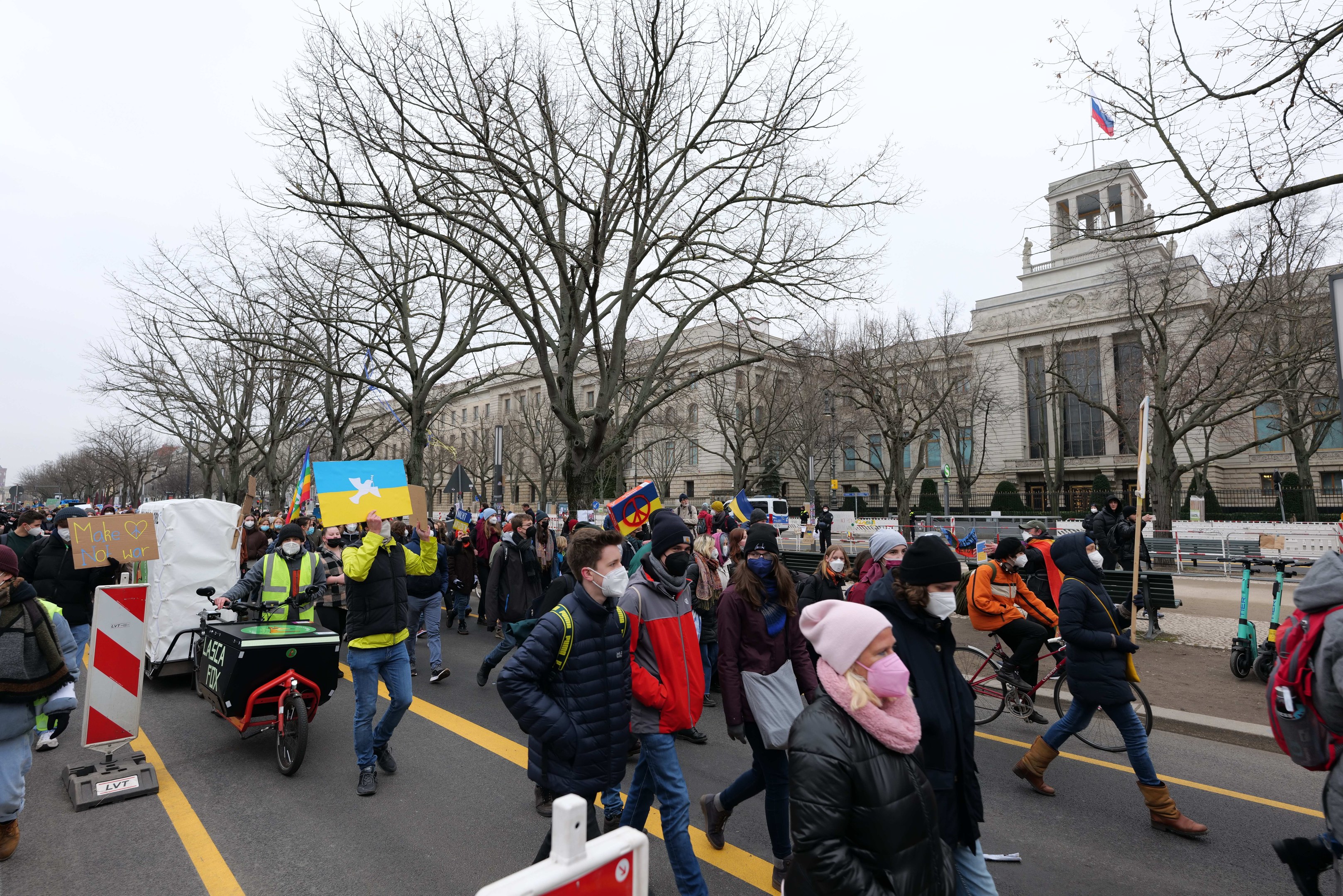 Eine große Gruppe von Menschen bei einer Demonstration auf einer Stadtstraße, einige halten Schilder und andere fahren Fahrräder, mit Bäumen und einem Gebäude im Hintergrund unter einem klaren blauen Himmel in Washington, D.C. am 21. Januar 2020.