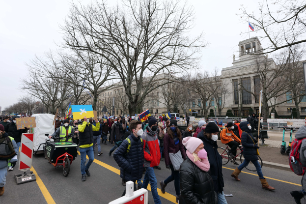 Eine große Gruppe von Menschen bei einer Demonstration auf einer Stadtstraße, einige halten Schilder und andere fahren Fahrräder, mit Bäumen und einem Gebäude im Hintergrund unter einem klaren blauen Himmel in Washington, D.C. am 21. Januar 2020.