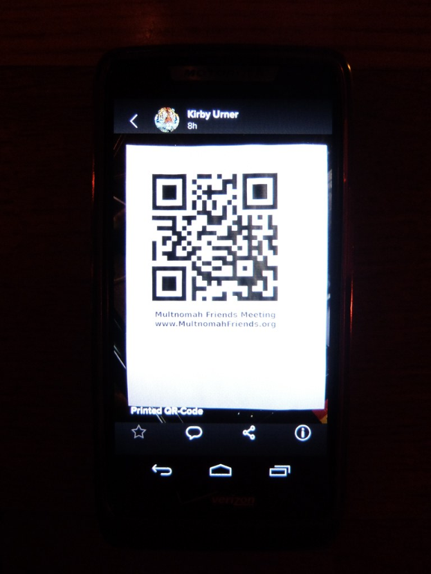 Ein Mobiltelefon mit einem QR-Code auf dem Bildschirm.