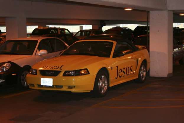 Ein Parkplatz voller Autos vor einem Gebäude.