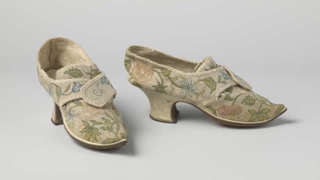 Frauen-Low-Heel-Schuhe mit gerundeten Zehen, mit floraler Stickerei in Rosa, Lila und Grün, auf einer weißen Oberfläche dargestellt.