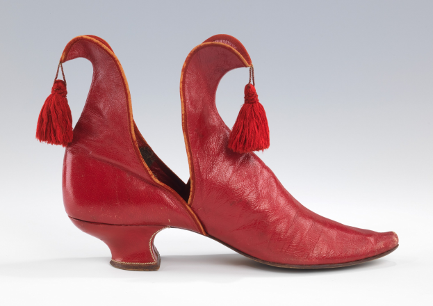 Rote Lederschuhe mit Quasten auf einem weißen Hintergrund.