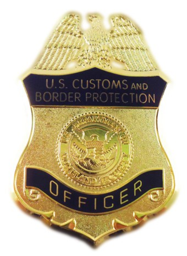 Goldenes Abzeichen mit der Gravur "U.S. Customs and Border Protection Officer" auf einem weißen Hintergrund.