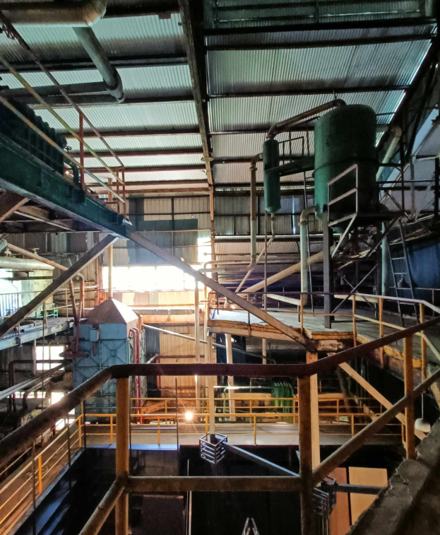 Großes industrielles Pyrolysewerk für Altreifen mit umfangreicher Maschine, Geländern, Treppen, Pfählen und Dach im Inneren.