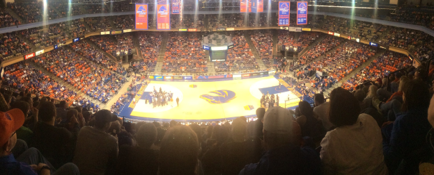Große Halle mit Zuschauern bei einem Basketballspiel, mit einem Spielfeld, Sitzplätzen, Deckenbeleuchtung und Bannern.