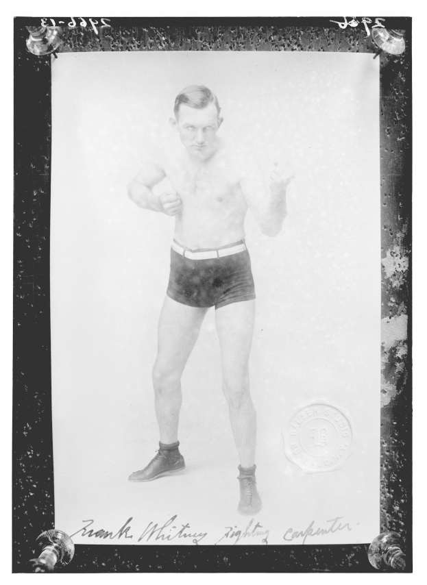 Schwarzes und weißes Foto eines Mannes in Boxershorts mit einem Stempel auf der rechten Seite und Text unten, der Schuhe trägt.