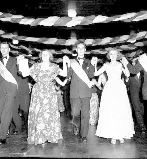 Schwarz-weißes Bild von formell gekleideten Menschen, die auf einer geschmückten Tanzfläche tanzen.