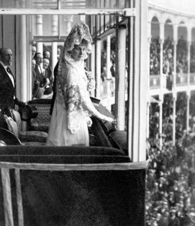 Schwarz-weißes Foto von Queen Elizabeth II. und Prinz Philip, Duke of Edinburgh, an ihrem Hochzeitstag in formeller Kleidung mit einer Menge und einem Gebäude im Hintergrund.