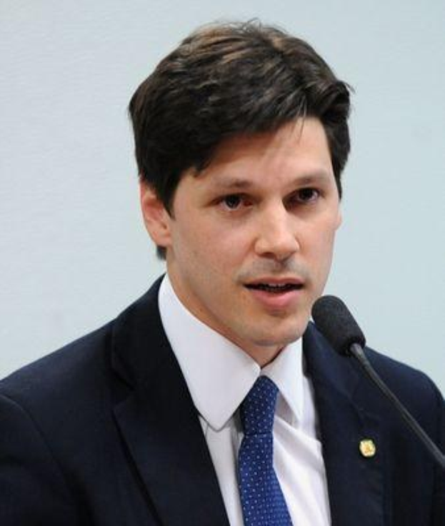 A suited man speaks into a microphone at a podium, likely addressing the government's approval of a bill to ban internet use.