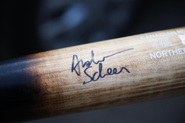 Nahaufnahme eines hölzernen Hockey-Schlägers mit einer Spieler-Signatur darauf.