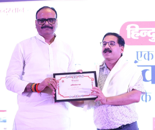 Zwei Männer mit Brille, die ein Zertifikat halten, vor einem Banner mit der Aufschrift "Maharashtra Tourism Awards 2019."