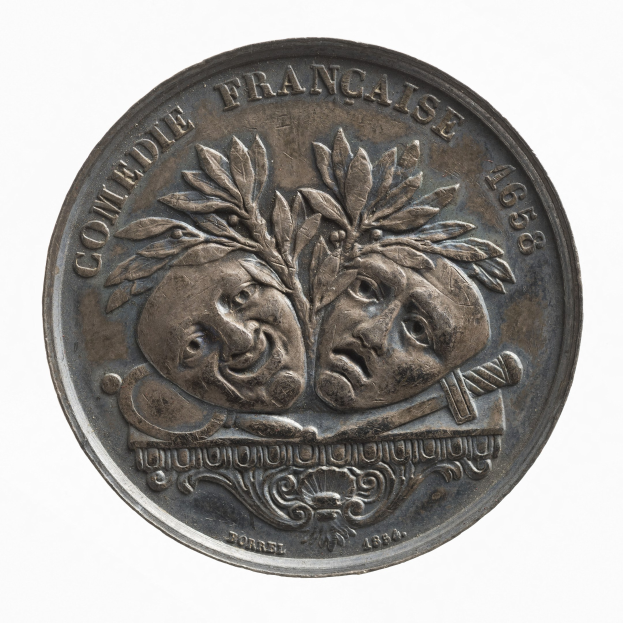 Silbermedaille mit zwei Gesichtern, eingraviert 'Comedie Francaise', auf einem weißen Hintergrund.