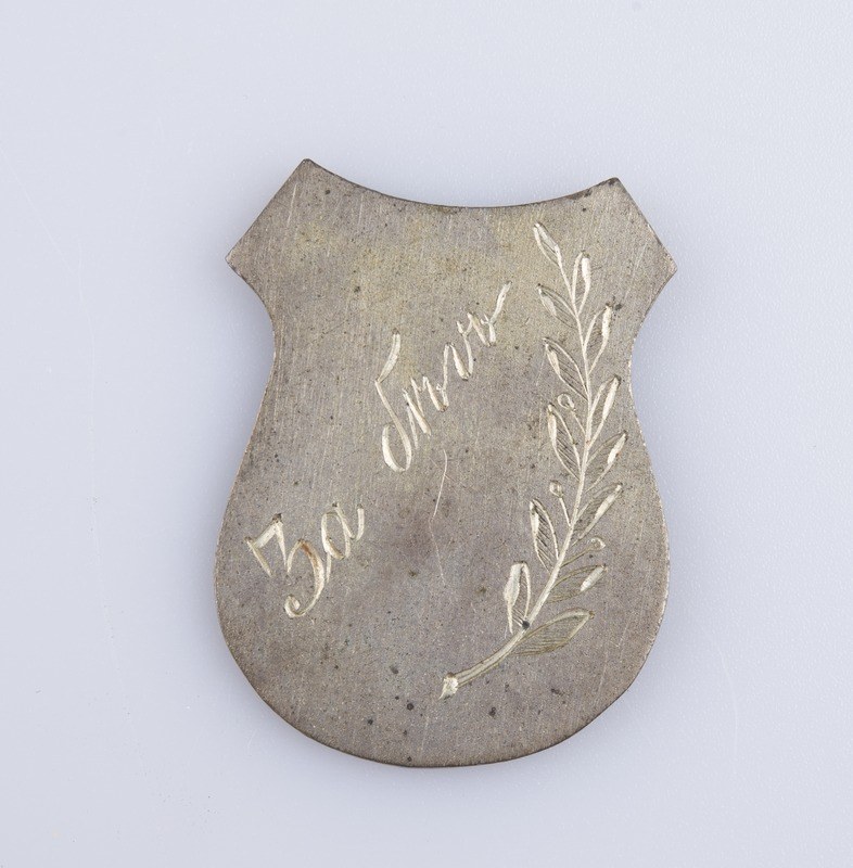 Ein silbergerändertes Abzeichen mit einem Lorbeerkranz, der die Inschrift "50-jähriges Jubiläum" trägt.