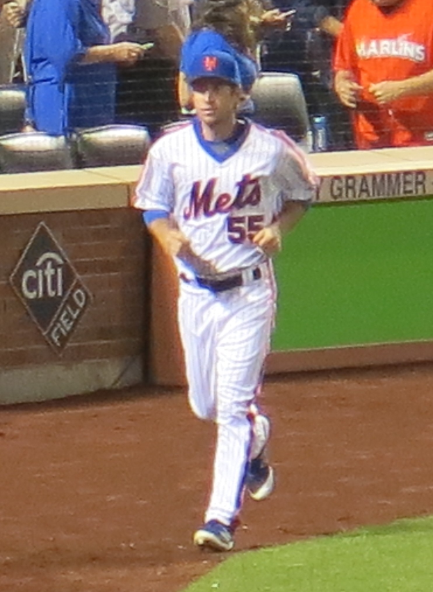 Ein Baseballspieler in einer Uniform rennt Richtung erste Base, während Zuschauer zuschauen