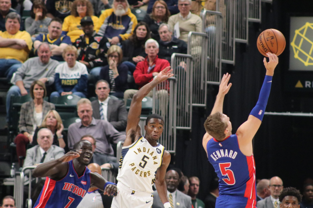 Basketballspiel zwischen den Indiana Pacers und den Detroit Pistons mit Zuschauern auf den Tribünen, einem Geländer im Hintergrund und einer Anzeigetafel rechts.