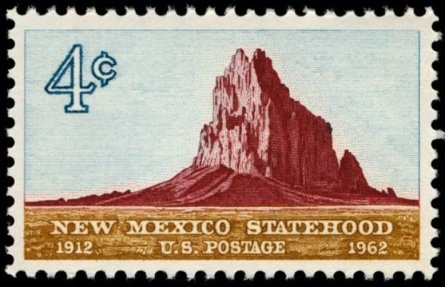 Eine Briefmarke mit den Worten "New Mexico Statehood" darauf, vor einem dunklen Hintergrund.
