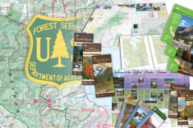 Eine Karte des United States Forest Service im Department of Agriculture, die ein Schild-Logo mit einem Baum und den Text "Forest Service" zeigt, umgeben von verstreuten Büchern und Broschüren.