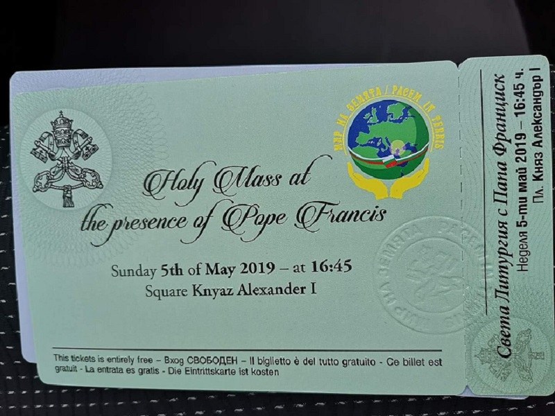 Schwarze Oberfläche mit einer Karte, auf der Text und ein Logo mit der Aufschrift "Heilige Messe in Gegenwart von Papst Franziskus" zu sehen ist.